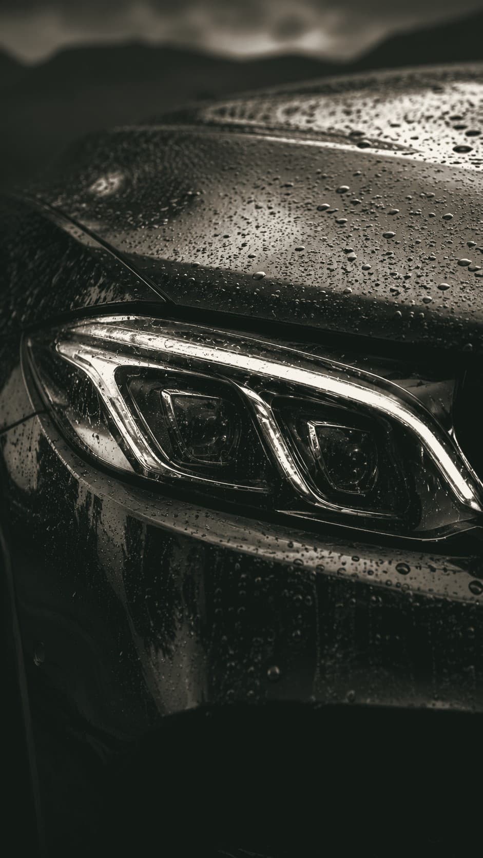 Rinse water beading on the coated hood and headlight of a black sedan