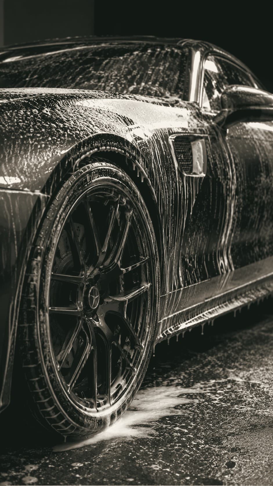 A foamy contact wash in progress on a black coupe